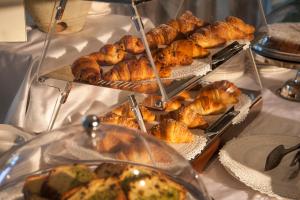 a buffet with several trays of pastries and other foods at Hotel Baia Del Capitano in Cefalù