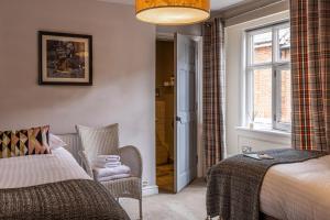 a bedroom with a bed and a chair and a window at The Crown & Horns in Newbury