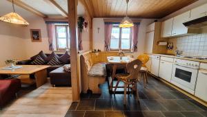 a kitchen and living room with a table and a couch at Ferienhaus Böck - Haus Karg in Seeg