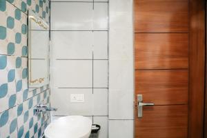 a bathroom with a toilet and a wooden door at ECKO Premier New Yoga in Badrīnāth