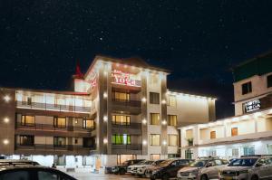 a hotel building with cars parked in a parking lot at ECKO Premier New Yoga in Badrīnāth