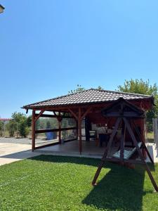 a wooden gazebo with a roof on the grass at Vila Diana in Venus +5 photos