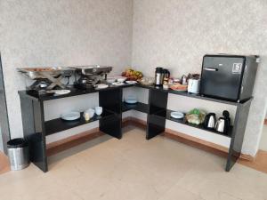 a kitchen with a counter with a refrigerator at Grand Manor Suites in Hyderabad
