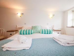 a bedroom with a large white bed with towels on it at Rosemaddon in Newquay
