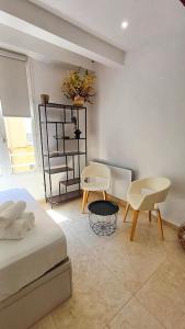 ein Schlafzimmer mit einem Bett und zwei Stühlen und einem Tisch in der Unterkunft Le Calisson, magnifique studio plein centre d'Aix in Aix-en-Provence