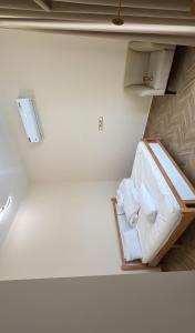 een kamer met een bed met witte lakens en handdoeken bij Bain Al Qimam in Hatta