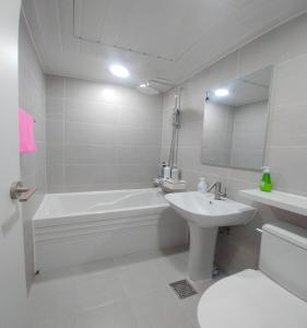 a white bathroom with a tub and a sink at Yeoju Hightel in Yeoju +32 photos