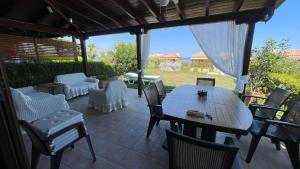 a wooden table and chairs on a patio at Ira's House Afitos in Afitos