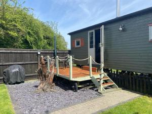 une terrasse sur le côté d'une petite maison dans l'établissement Natures Nook - Luxury XL Wagon Louth Lincolnshire, à Louth