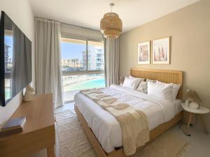 a bedroom with a large bed and a large window at BirdNest Vacation homes at Marassi marina in El Alamein +272 photos