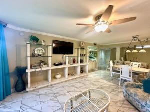 a living room with a ceiling fan and a dining room at Paradise Found Cayo Hueso in Key West