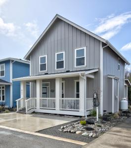 a gray house with a white front porch at Back To The Beach in Ocean Shores