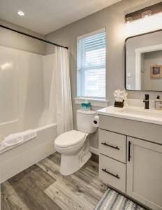 a bathroom with a toilet and a sink and a mirror at Back To The Beach in Ocean Shores +32 photos