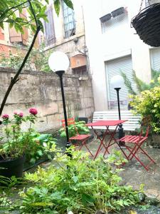 a patio with a table and chairs and flowers at Studio 1 centre ville RDC in Bar-le-Duc