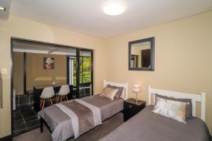 a bedroom with two beds and a mirror at Heathercreek Accommodation in George