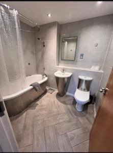 a bathroom with a tub and a sink and a toilet at Cardiff Central Luxury Apartment 2 bed, whit Free parking in Cardiff