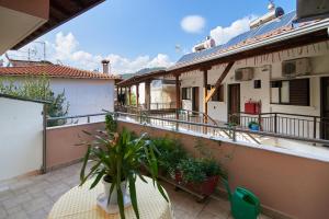 a balcony of a house with a table and plants at Sartoupoli in Sarti