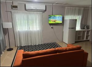 a living room with a couch and a flat screen tv at Anibare Home Stay in Anibare