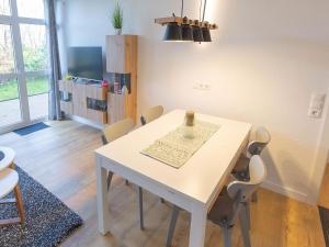 a dining room with a white table and chairs at Ferienwohnung Abbey Road in Varel +12 photos