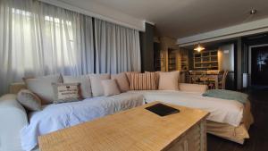 ein Wohnzimmer mit Sofa und Tisch in der Unterkunft Velvet Pines Villa, Elani by Halkidiki Villas in Elani