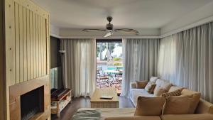 ein Wohnzimmer mit Couch und Kamin in der Unterkunft Velvet Pines Villa, Elani by Halkidiki Villas in Elani