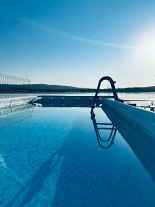 a swimming pool with blue water next to a bridge at Casa LaMal in Divici