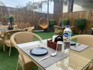 a table with plates and a bottle of water on it at Taj Castle by iO Hotels in Amritsar