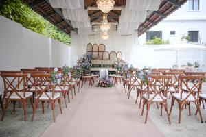 a row of tables and chairs in a room with flowers at Luxury Tropical Bungalow in Damansara Golden Core in Kuala Lumpur