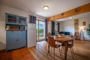 a kitchen and a dining room with a table and chairs at River Cottage Bešeňová in Bešeňová