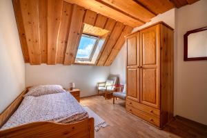 a bedroom with a bed and a wooden ceiling at River Cottage Bešeňová in Bešeňová