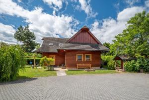 a log house with a gambrel roof and a bench at River Cottage Bešeňová in Bešeňová