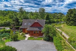 an aerial view of a log house with a yard at River Cottage Bešeňová in Bešeňová