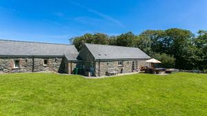 a stone house with a lawn in front of it at Ty Siam in Newborough