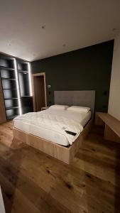 a large bed in a bedroom with a green wall at Casa Lucia in Valdidentro