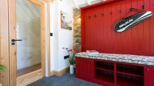 a red wall with a surfboard on the wall at Ty Siam in Newborough +78 photos