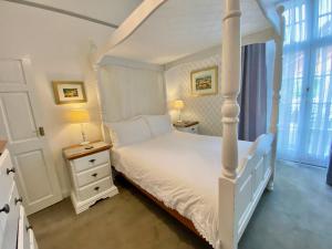 WE ARE UNIQUE ! 4 min walk to Beach, Pubs, Restaurants, Shops, Htd Pool, Hottub, Games rm, 1 acre Garden, BBQ, Stunning walks, Historic Bassets acre, 6 x 1-3 bedroom Superior aparts, Free Parking and WIFI في برتريث: غرفة نوم بسرير أبيض وطاولتين جانبيتين +29 صورة