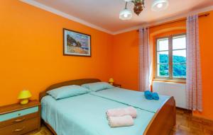 a bedroom with orange walls and a bed with towels on it at Villa Draga by Villas Guide in Mošćenička Draga
