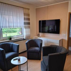 a living room with two chairs and a flat screen tv at Ferienwohnung Hof Segberg in Langenberg