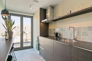 ドンブルグにあるHello Zeeland - Appartement Stationsstraat 5aのシンクと大きな窓のあるキッチン