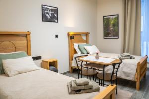 a room with two beds and a table in it at Teatar Rooms Subotica 4 in Subotica