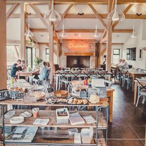 a restaurant with tables and people sitting at tables at Carp's Rise Cottage in Somerford Keynes