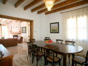 Una sala de estar con una mesa y sillas de madera. en Villa Son Capellet casa con piscina en Petra, en Petra