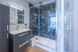 a bathroom with a glass shower and a sink at Le penthouse des ours in Courseulles-sur-Mer