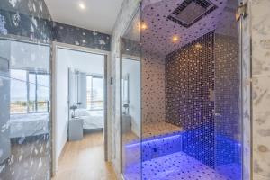 a bathroom with a walk in shower next to a bedroom at Le penthouse des ours in Courseulles-sur-Mer +5 photos