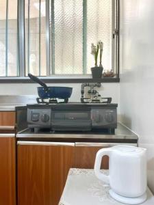 a kitchen with a stove with a pot on it at Nippori Osaka Nishi-Tengachaya Guesthouse西天下茶屋アパートメント in Osaka