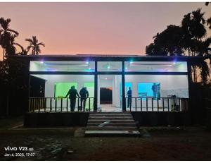two people standing in a building with blue lights at namaste Adoroni Guest House , Manas National Park in Jyoti Gaon