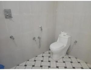 a bathroom with a toilet in a white room at namaste Adoroni Guest House , Manas National Park in Jyoti Gaon
