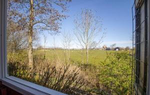 a view of a field from a window of a house at 1 Bedroom Stunning Home In Menaam in Dronrijp +6 photos