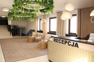 a hotel lobby with a reception desk and plants at Centrum Wypoczynkowo-Szkoleniowe Ostrzyce in Ostrzyce
