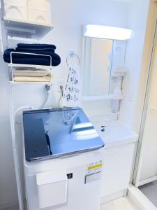 a white refrigerator with a sink and a mirror at 鶴見 House 105 in Yokohama